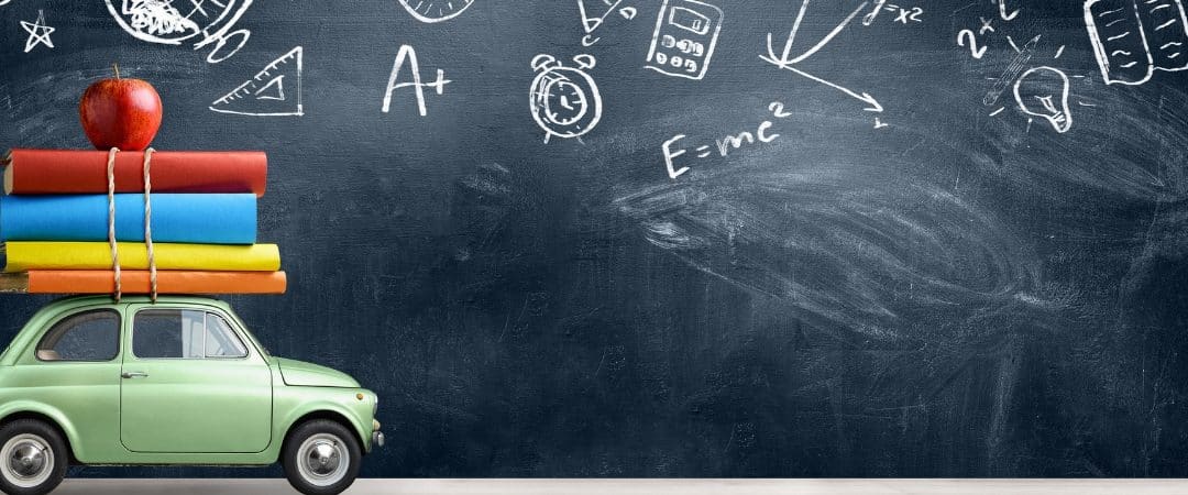 Toy car carrying books in front of chalkboard