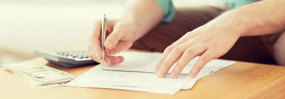 close up of someone signing a contract for borrowing money